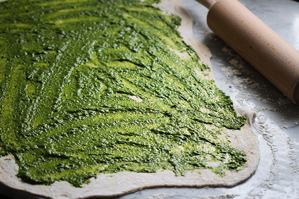 Teig ausrollen und mit reichlich Pesto bestreichen